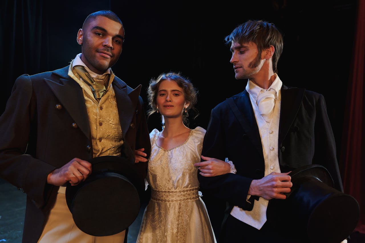 services-02 Actors in period costumes pose on stage, embodying classic theatrical drama.