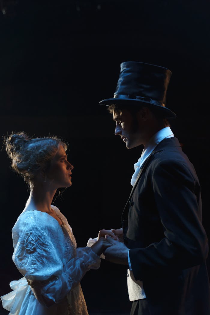 how-it-works A dramatic theater scene depicting a couple in Victorian attire holding hands on stage.